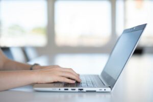 gros plan d'une personne tapant sur un ordinateur portable