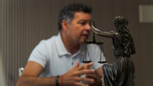 Un homme assis à une table devant une statue